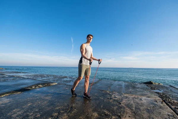 Mladý Fit Mužský Trénink Atletickou Gumou Pláži Letní Den — Stock fotografie