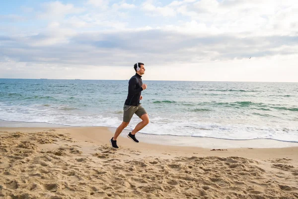 Ajuste Entrenamiento Corredor Masculino Playa Verano Escuchar Música Contra Cielo — Foto de Stock