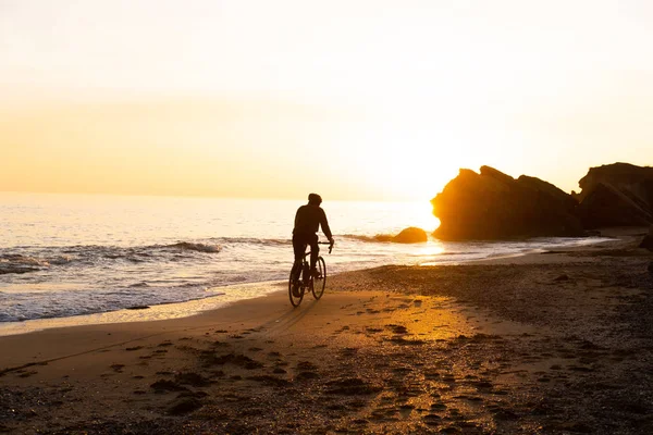 Силует Молодого Чоловіка Велосипедиста Шоломі Пляжі Під Час Красивого Заходу — стокове фото