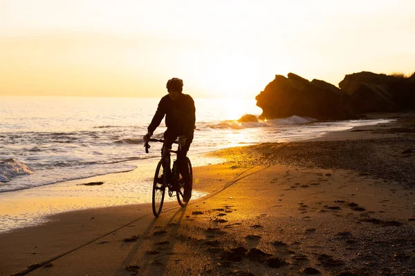 Силует Молодого Чоловіка Велосипедиста Шоломі Пляжі Під Час Красивого Заходу — стокове фото