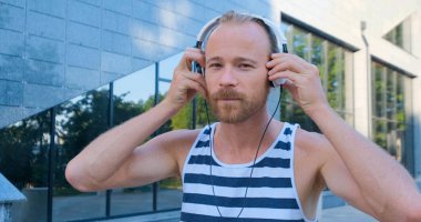 Kulaklıklı genç yakışıklı erkek portresi.