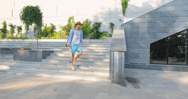 Knappe Jonge Man Met Skateboard Buiten Stad Luisteren Naar Muziek — Stockfoto