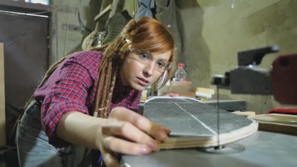 年轻的红头发嬉皮士女人带着可怕的头发在车间修理旧滑板和使用电动工具 — 图库视频影像