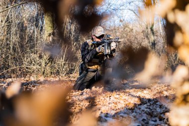Ormanda tüfeği olan özel askeri birlikten bir erkek.