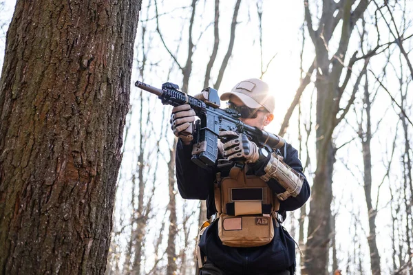 森の中にライフルを持つ民間軍事会社の男性 — ストック写真