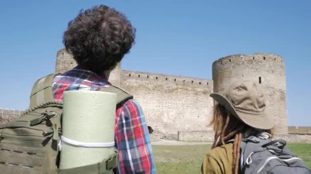 一对年轻夫妇带着背包在中世纪城堡里游览古堡 — 图库视频影像