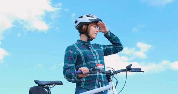 Young woman bicycle rider in sunny summer day
