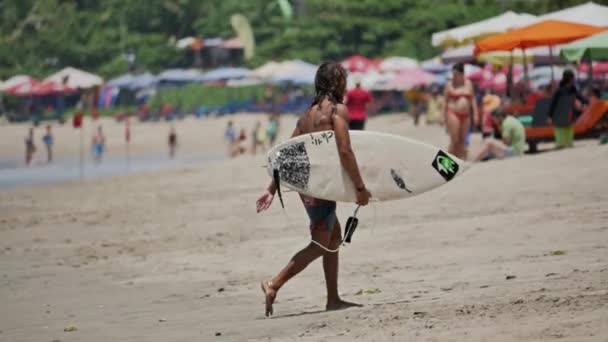 Jente som går på stranden med surfebrettet i hånden – stockvideo