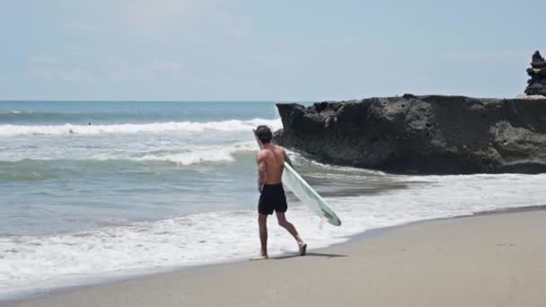 Surfer na plaży wybrzeża w Indonezji — Wideo stockowe
