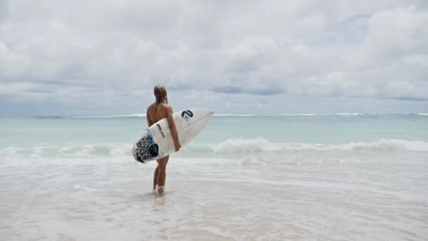 Mädchen am Strand mit Surfbrett in der Hand — Stockvideo