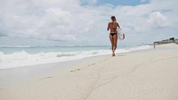 Meisje lopen op het strand met haar surfboard in haar hand — Stockvideo