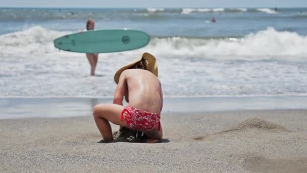 Ragazzina che siede sulla spiaggia — Video Stock