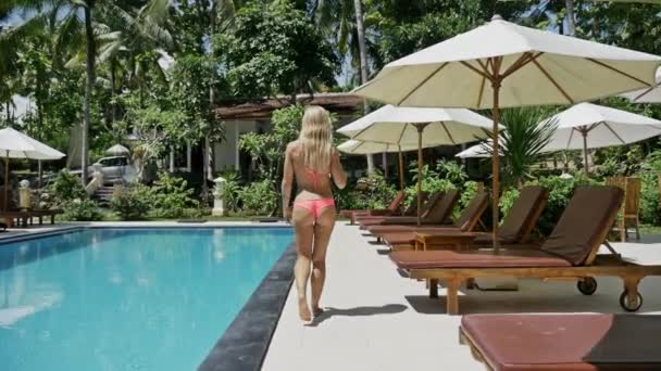 Dziewczyna, chodzenie w pobliżu basenu na resort — Wideo stockowe