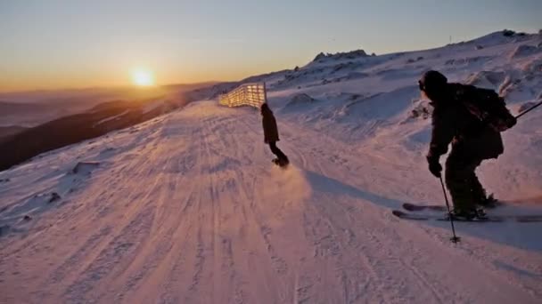 Skifahrer und Snowboarder auf der Piste — Stockvideo