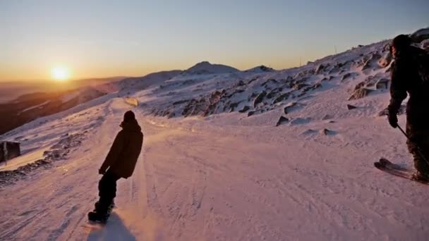 Kayakçı ve yamaç sürme snowboarder — Stok video