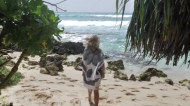 Mavi okyanusun içinde Weligama, Sri Lanka kayalık sahil üzerinde plaj elbiseli genç kadın