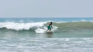 Sörfçü Weligama mavi okyanusta dalgaları üzerinde genç adam 