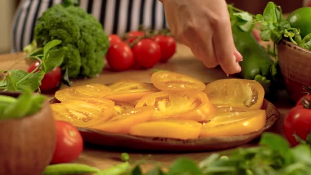 Sprinkles salt on yellow tomatoes. — Stock Video