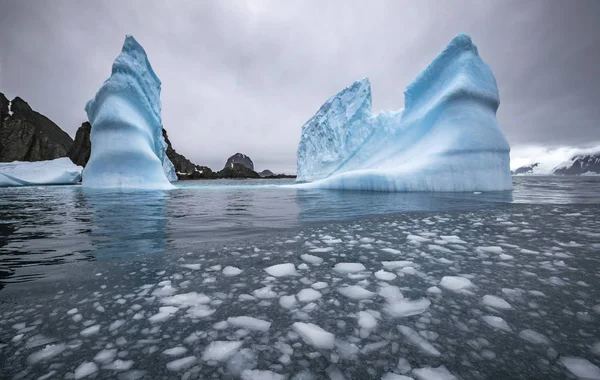 Paisagem de icebergs e rochas no mar. Pedaços de gelo flutuam na água. Andreev . Fotografias De Stock Royalty-Free