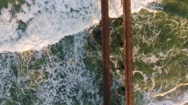 Vista aérea de um cais de madeira e ondas do Oceano Atlântico na praia de Swakopmund, na Namíbia . — Vídeo de Stock