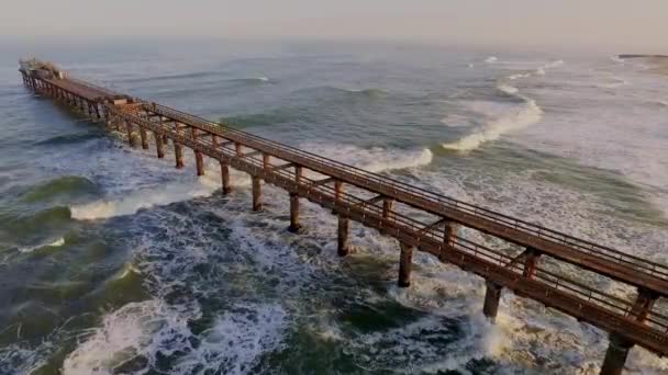 View from the air a wooden pier goes into the ocean. — Stock Video