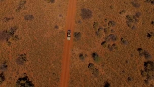 Вид с воздуха: внедорожник с людьми, путешествующими по дороге в саванне Намибии . — стоковое видео
