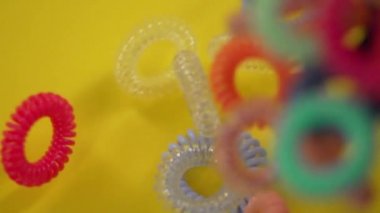 Saçlar için farklı renklerde plastik kauçuk şeritler yüzeyinde düşmek.