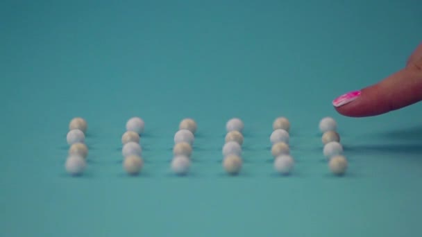 Närbild av pärlemorliknande bollar av pulver på en blå yta. — Stockvideo