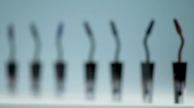 Mavi bir arka plan üzerinde üst üste maskara için fırçalar standı.