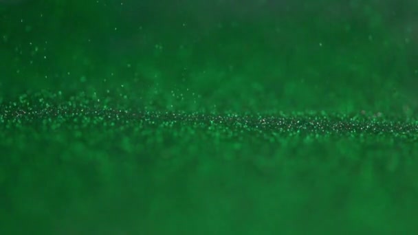 The green glitter falls to the surface. — Stock Video