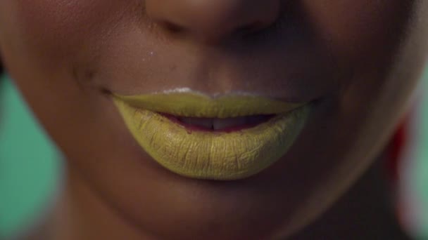 Lächeln einer dunkelhäutigen Frau mit gelbem Lippenstift auf den Lippen. — Stockvideo