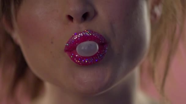 Schön bemalte weibliche Lippen blasen Kaugummi auf. — Stockvideo