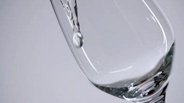 Şeffaf sıvı şarap bardağını doldurur.