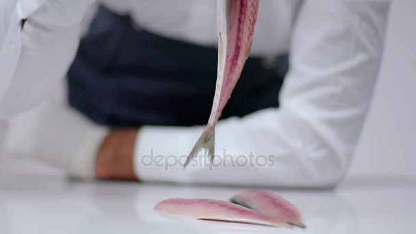 El cocinero mantiene el cuerpo y la cola del pescado en el aire . — Vídeo de stock