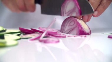 Cook hızlı bir şekilde mor soğan bir bıçak ile kesmek..