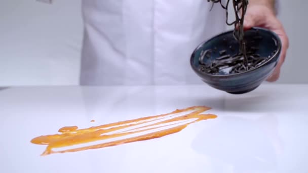 Hands of the cook spread on a white table with cream black pasta. — Stock Video