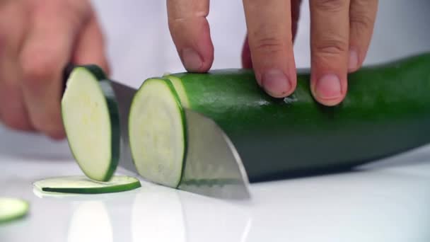 Cooks hands cut the cucumber on a white surface. A — Stock Video