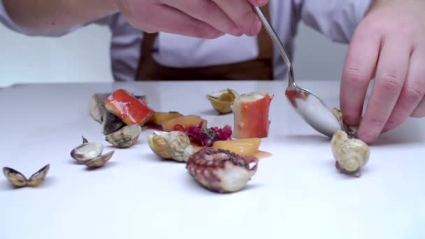 The cook carefully puts the mussels on a white table. — Stock Video