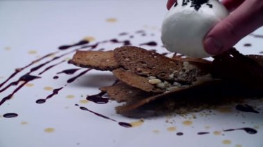 Beyaz topu siyah ekmek üzerinde beyaz bir tablo içinde yatırılır.