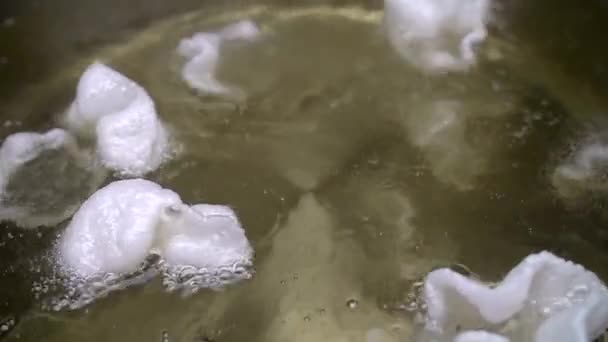 Massa de ar branca é fervida em água fervente . — Vídeo de Stock