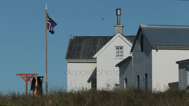 Vista de uma casa branca com um mastro de bandeira e raios de madeira onde secar coisas. Andreev . — Vídeo de Stock