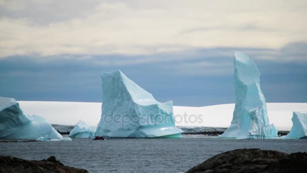 Turistas en un barco de goma navegan entre icebergs. Andreev. . — Vídeo de stock