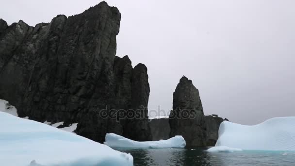 Bitar av glaciären flyta runt klipporna i havet. Andreev. — Stockvideo