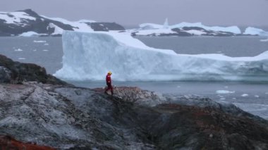 Bir adamın Antarktika kayalarda girer. Andreev.