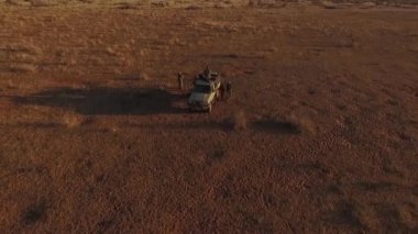 Avcılar savana arabada etrafında durmak.