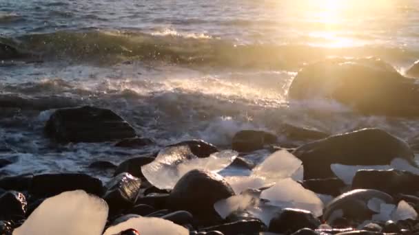 Trozos de hielo yacen entre las piedras de la orilla. Andreev. . — Vídeo de stock