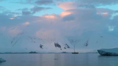 Yat karla kaplı dağlar ve beyaz bulutlar arka plan karşı duruyor. Andreev.