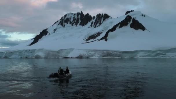 Mensen zijn beurt op een rubberboot tegen de achtergrond van de gletsjer. Andrejev. — Stockvideo