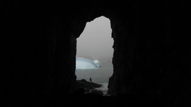 A man stands at the entrance to the cave near the water. Andreev. — Stock Video