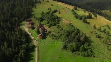 Dron ormanın ortasında evler üzerindeki yükseklik kazanıyor.